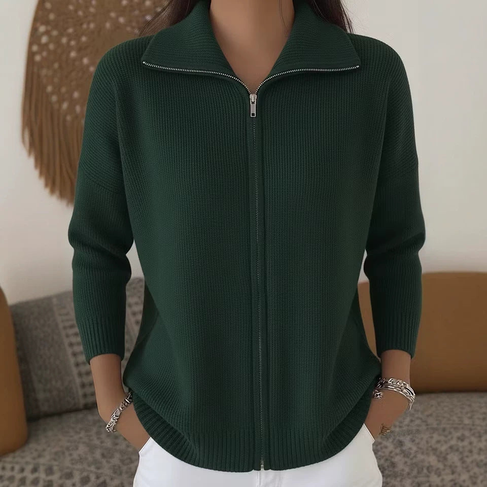 Person wearing a green zip-up sweater in a casual setting