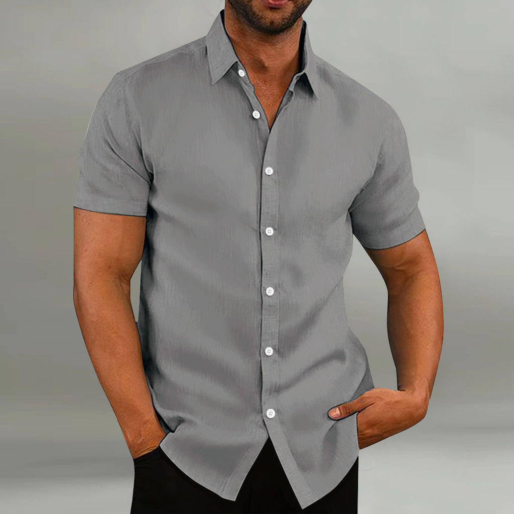 Man wearing a gray short-sleeve button-up shirt against a plain background
