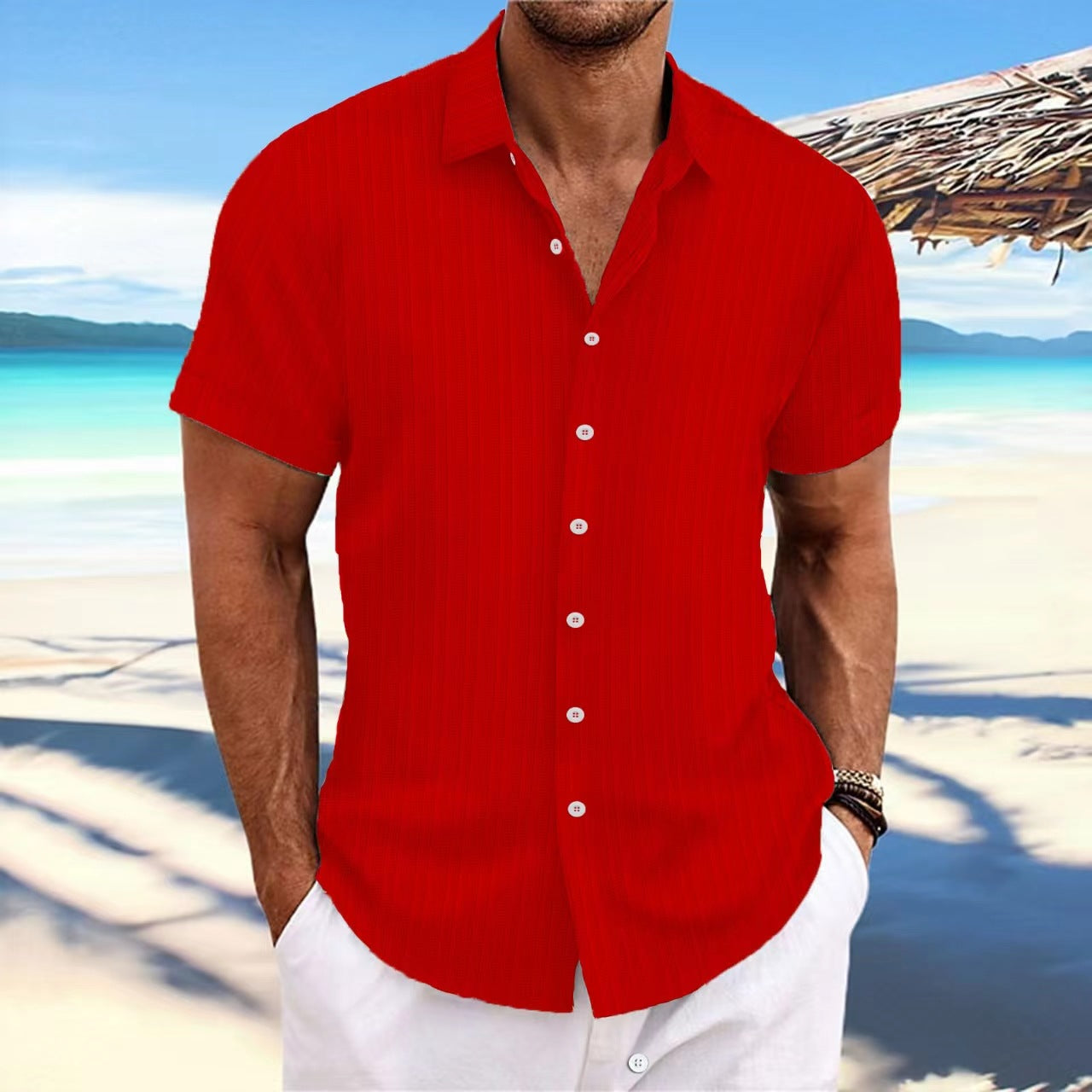 Man wearing a red shirt and white pants on a beach