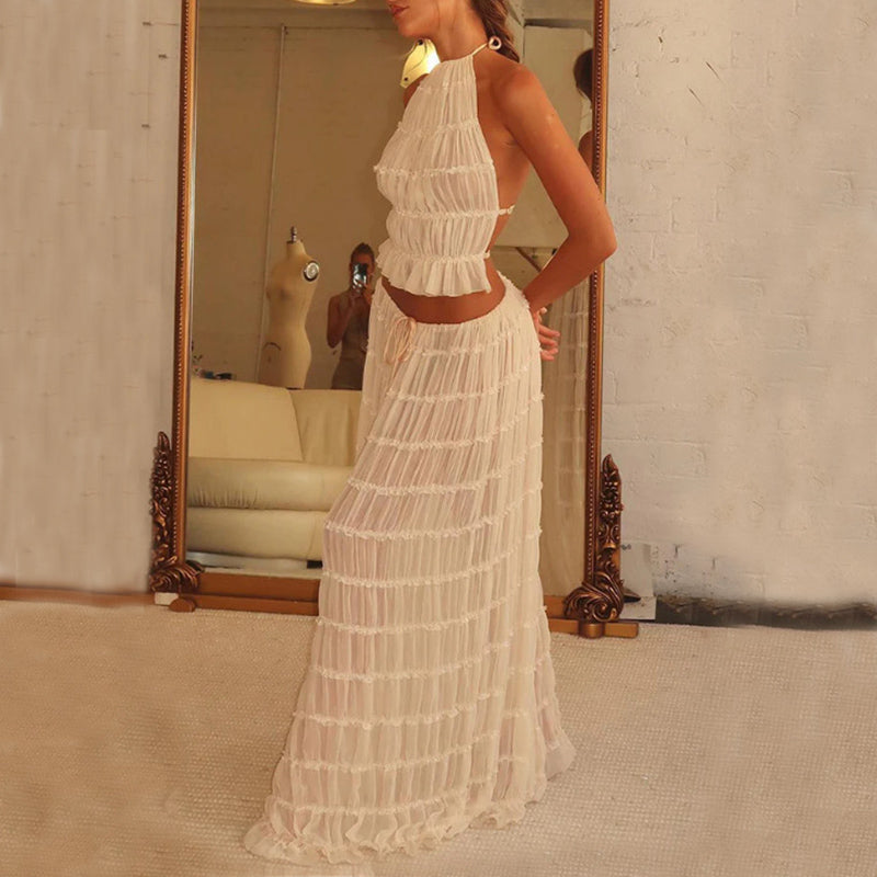 Woman wearing a white lace dress standing in front of a mirror.