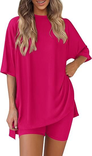 Woman wearing a bright pink oversized t-shirt and shorts set on a white background