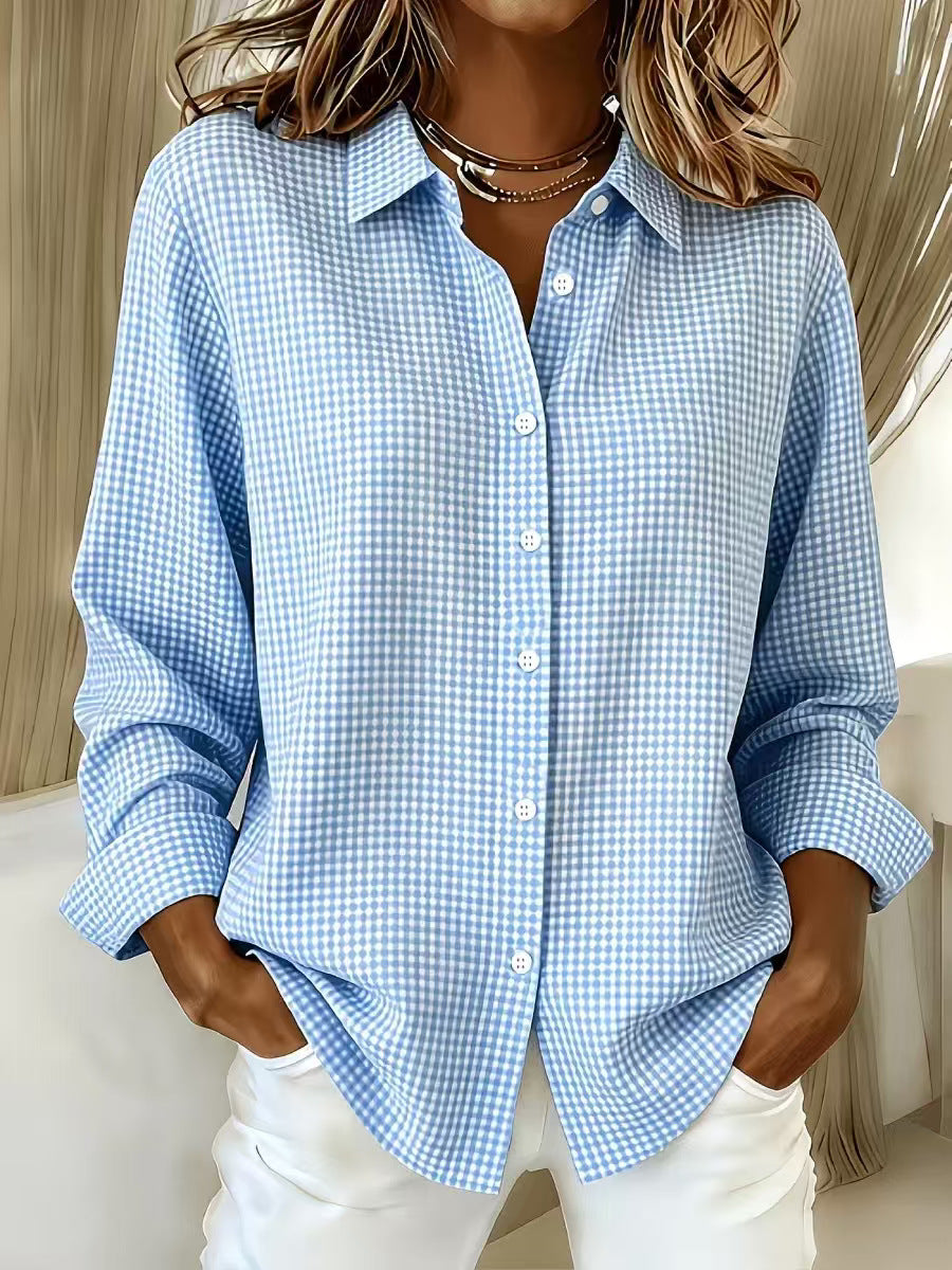 Person wearing a blue checkered shirt with rolled-up sleeves and white pants.