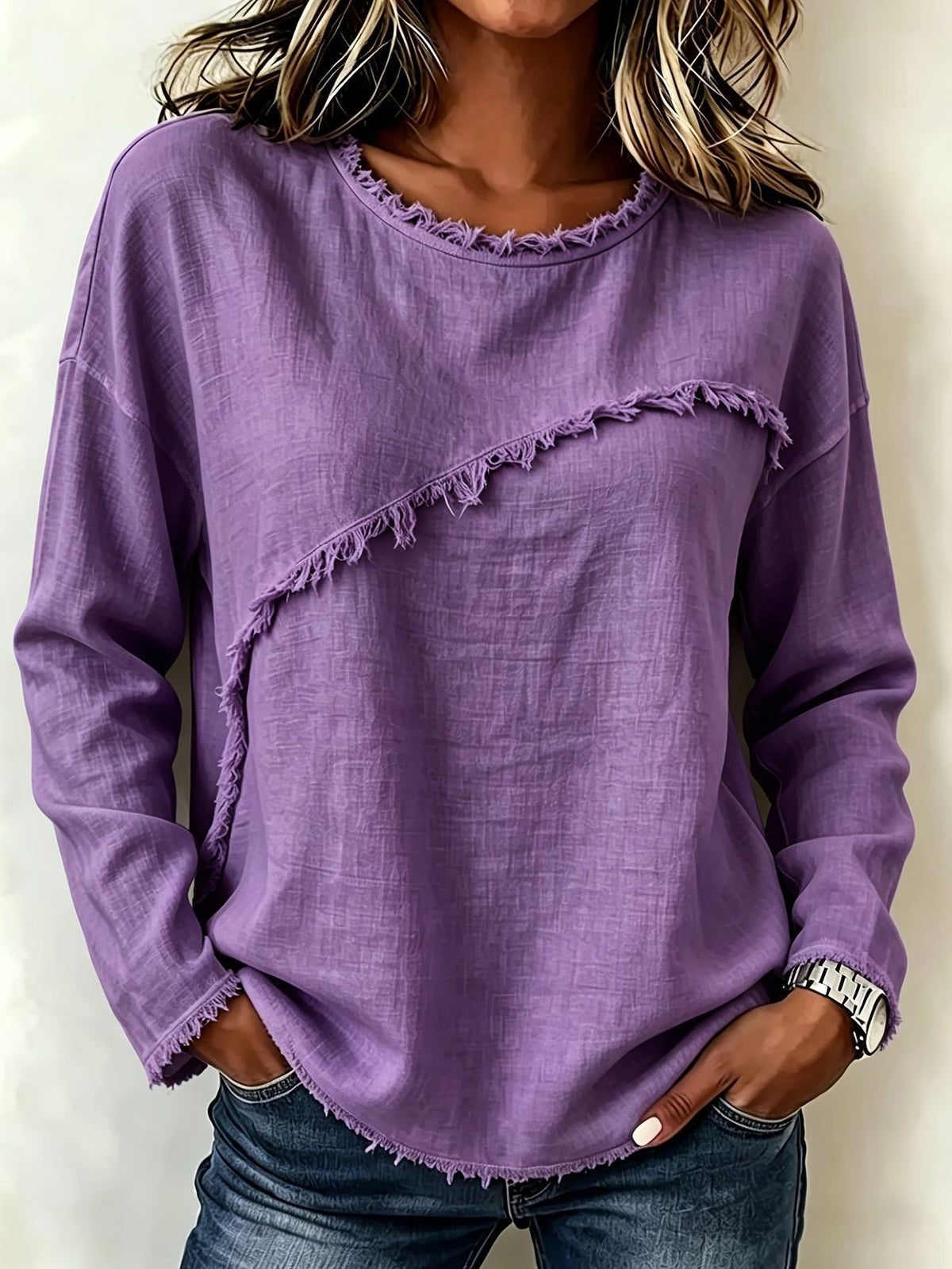 Person wearing a purple sweater with frayed edges on a plain background