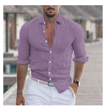 Man wearing a purple button-up shirt with rolled-up sleeves and white pants outdoors.