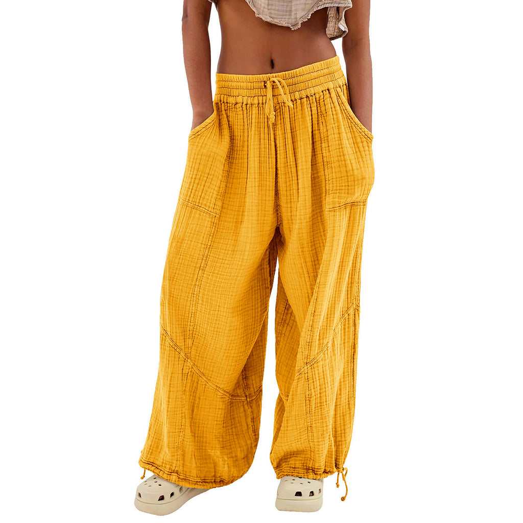 Yellow wide-leg pants worn by a person on a white background