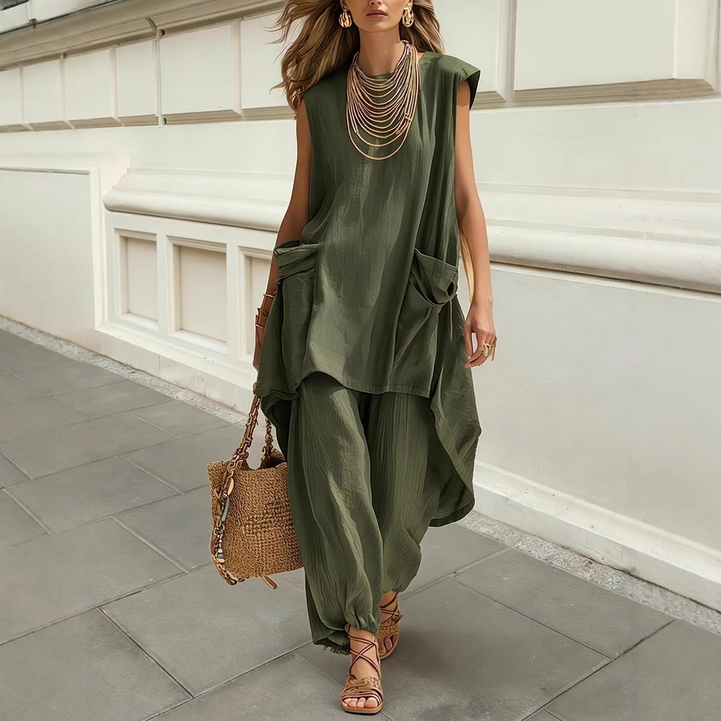 Woman in a green outfit standing on a stone pavement with a white wall background
