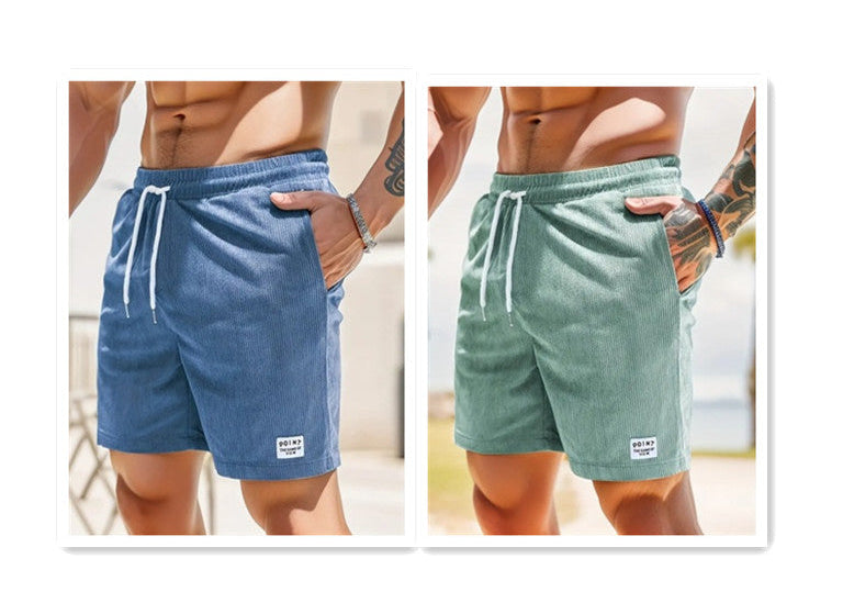 Two pairs of shorts, one blue and one green, worn by a person with a neutral background.