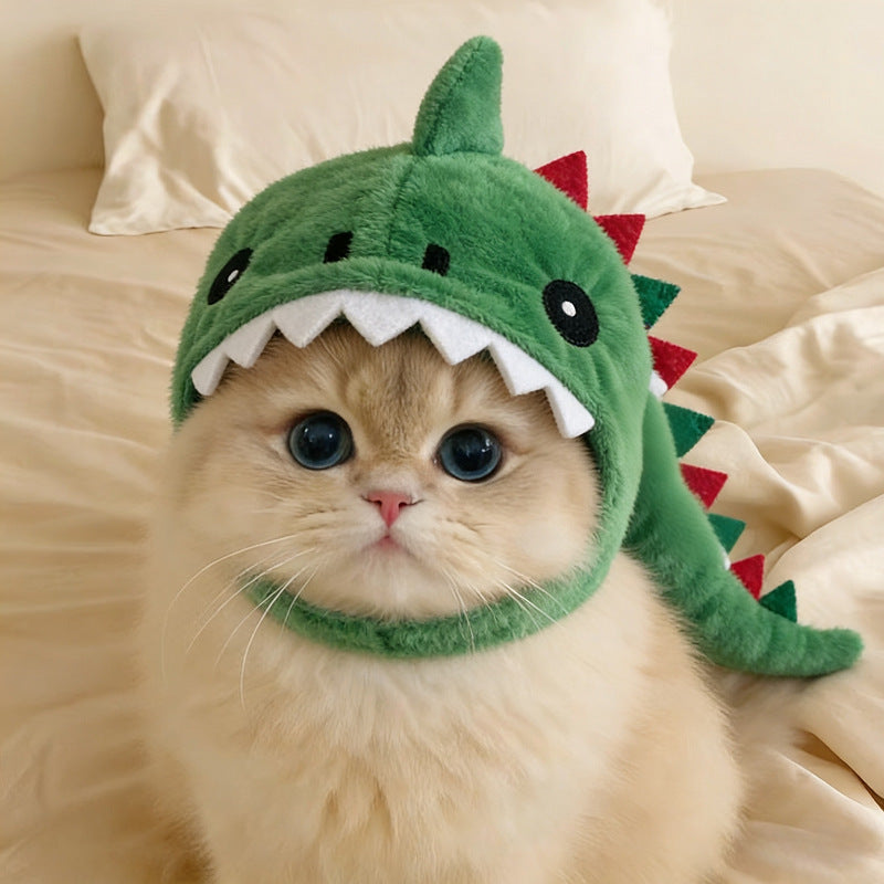 Cat wearing a green dinosaur hat on a beige couch