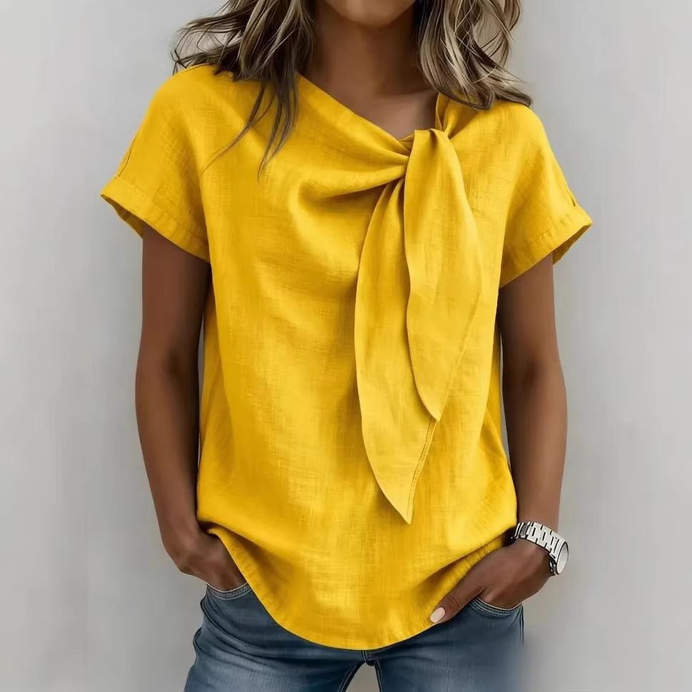 Yellow top with a bow detail worn by a person on a plain background