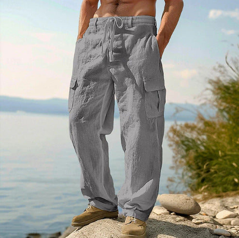 Person wearing gray cargo pants standing on a rocky outcrop with a scenic background.