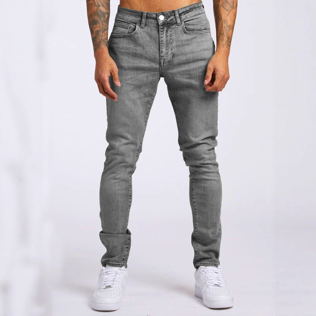 Person wearing gray jeans and white sneakers on a white background