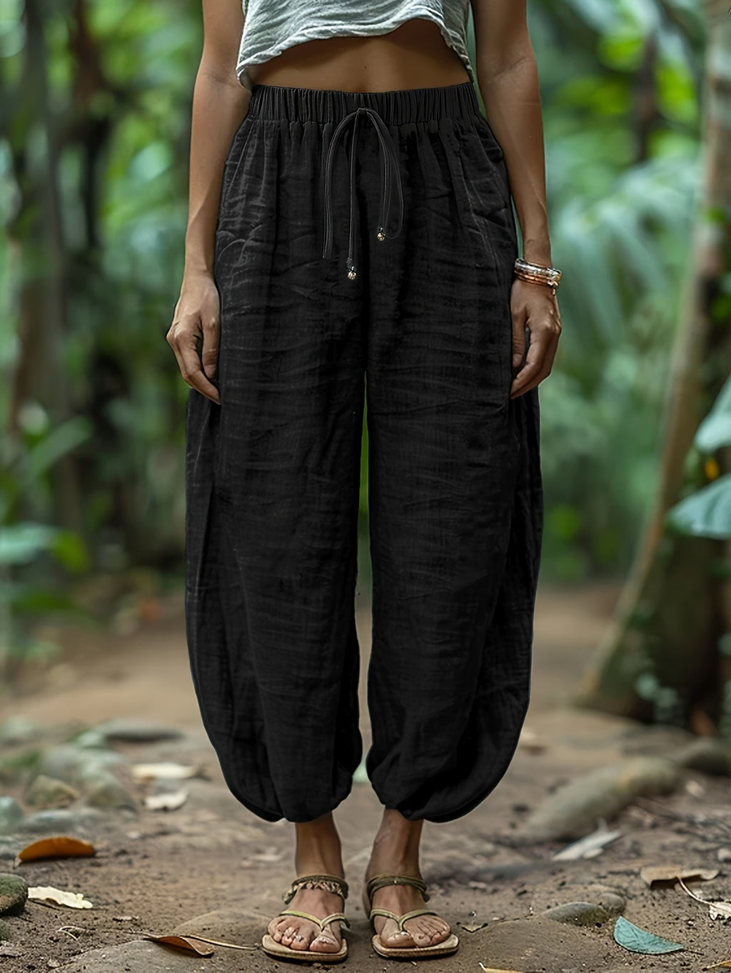 Person wearing black wide-leg pants with a blurred natural background