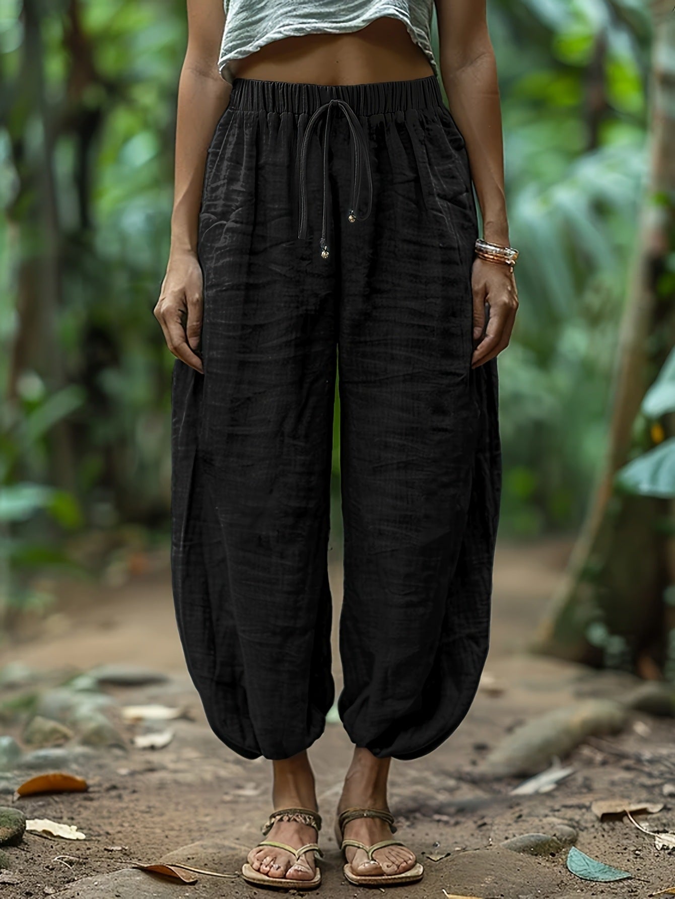 Person wearing black wide-leg pants with a blurred natural background