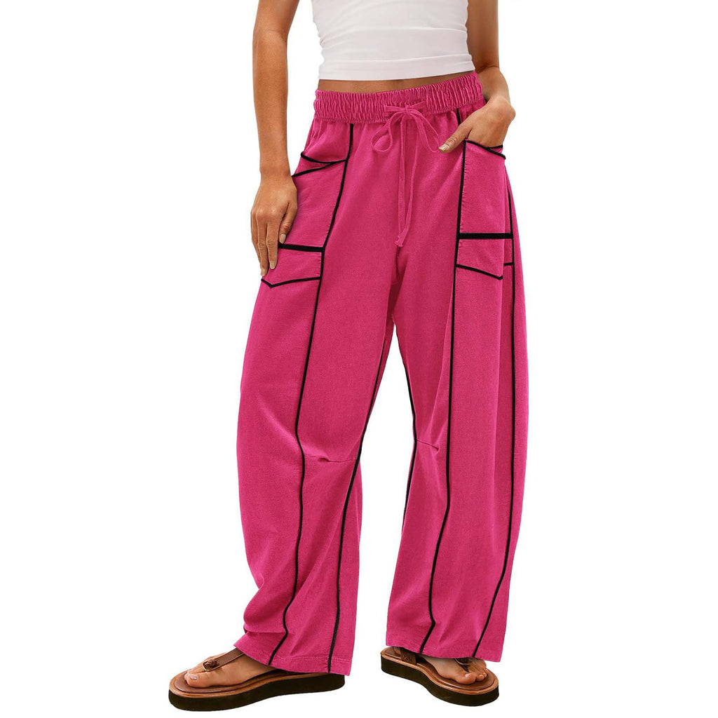 Person wearing bright pink pants with black accents on a white background