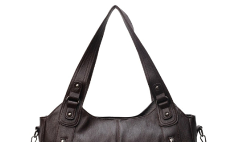 Black handbag with multiple straps on a white background