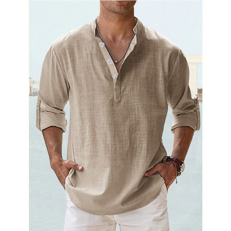 Man wearing a beige linen shirt with rolled-up sleeves against a light blue background