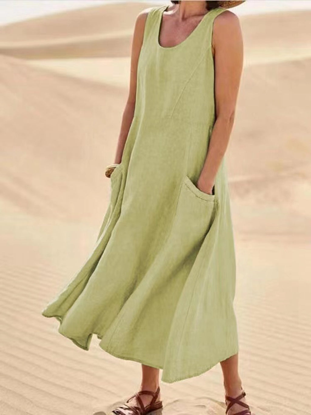 Person wearing a light green sleeveless dress in a desert setting