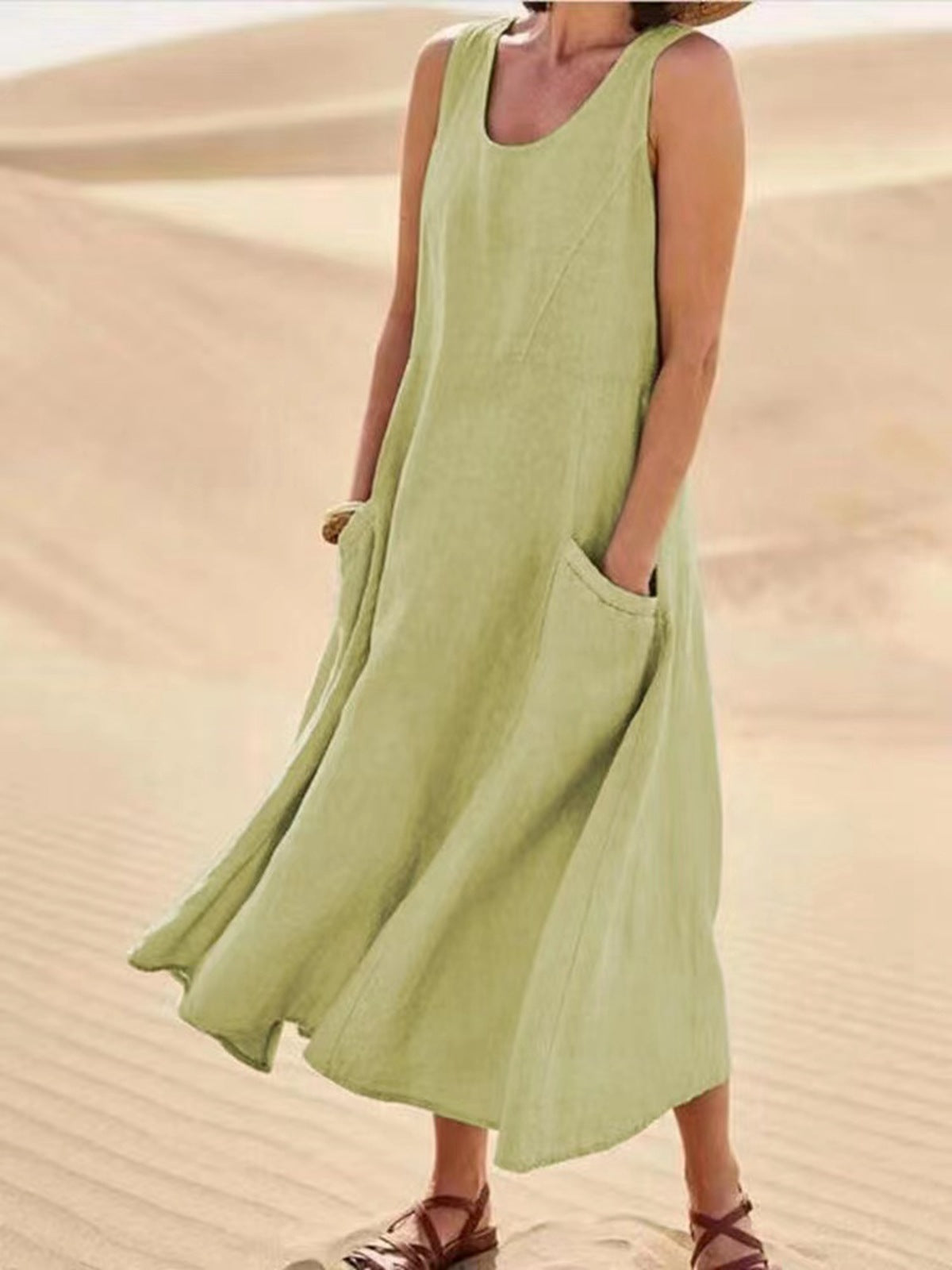 Person wearing a light green sleeveless dress in a desert setting
