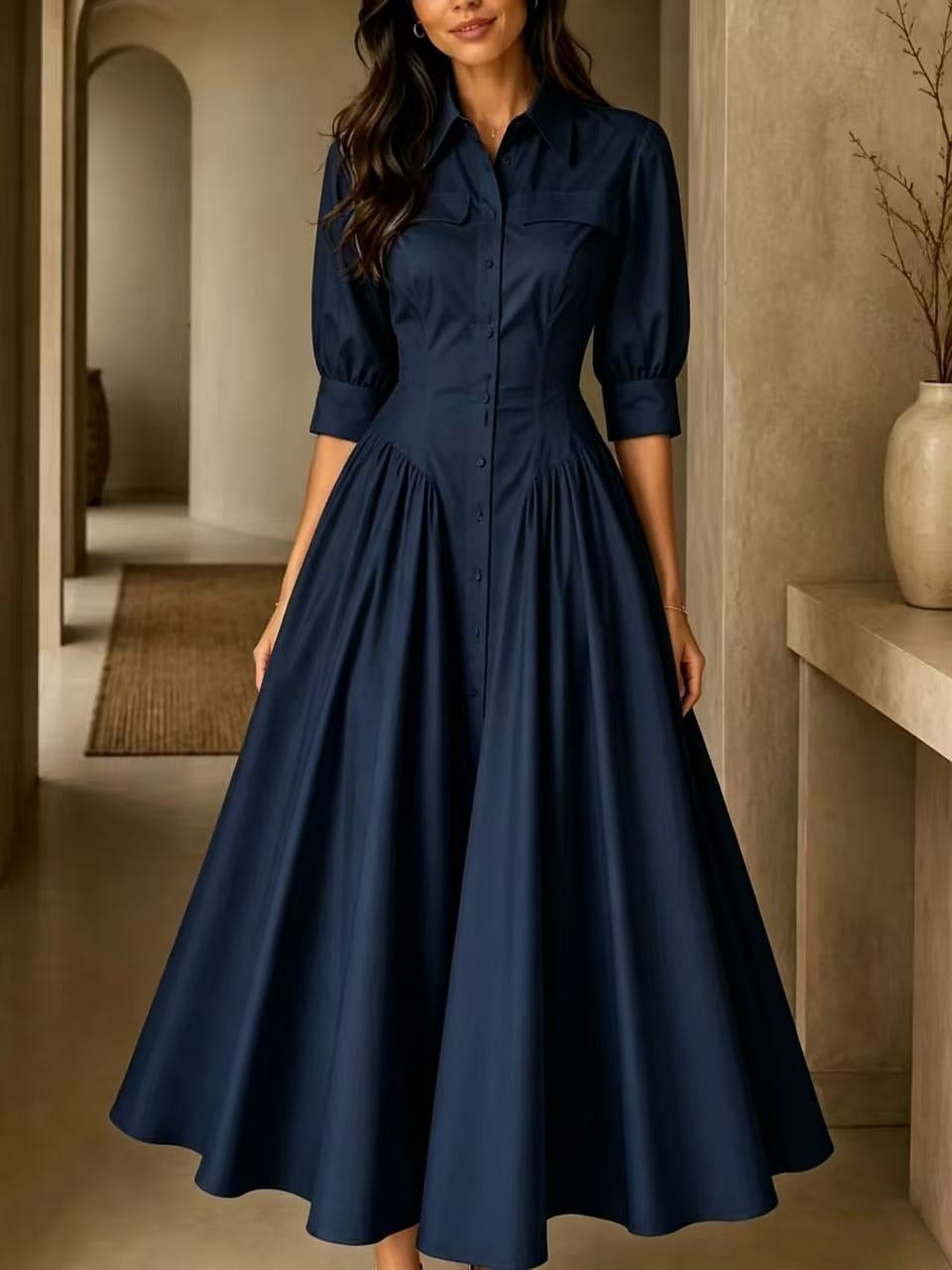 Woman wearing a navy blue dress in an indoor setting