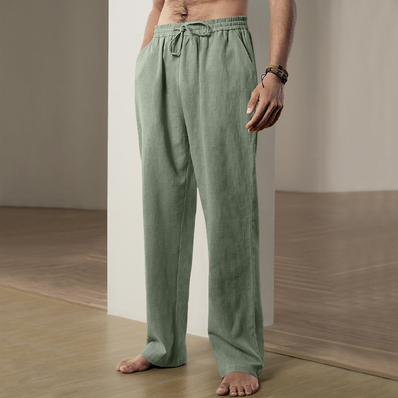 Person wearing green pants standing in a minimalistic room.