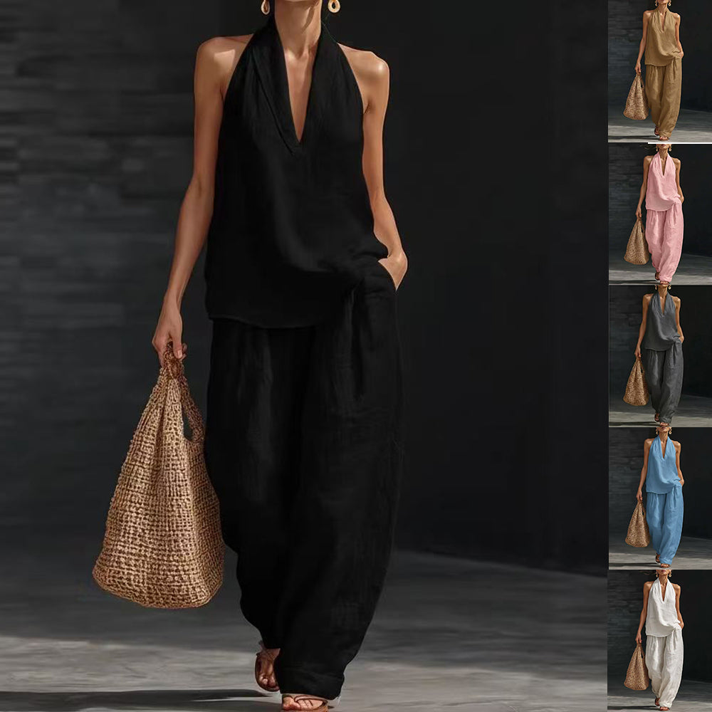 Woman in black outfit holding a woven bag against a dark background