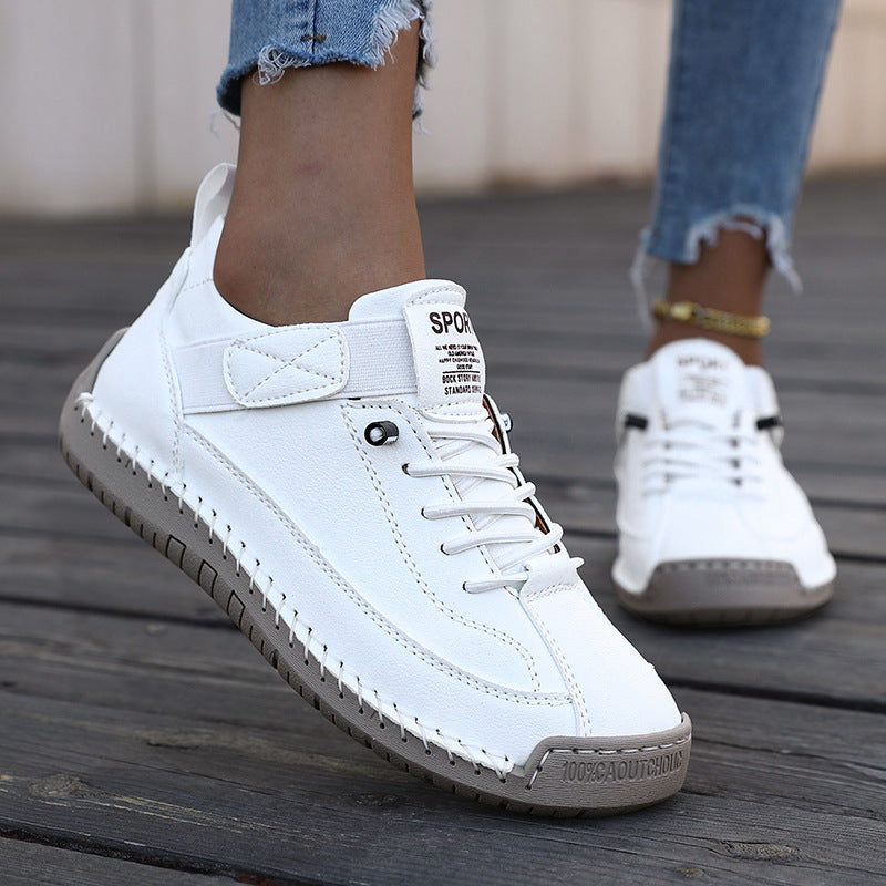 White sneakers with gray soles on a wooden floor