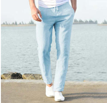 Person wearing light blue jeans standing by a waterfront.