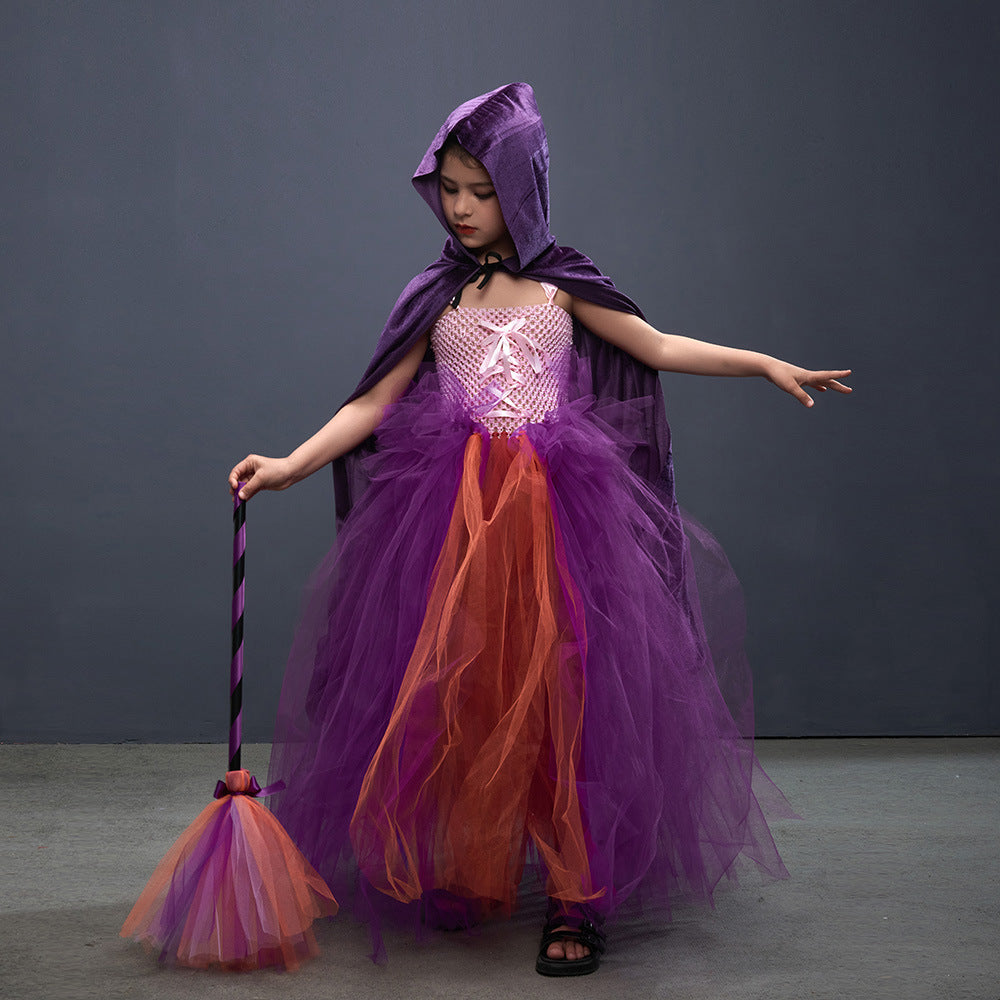Child in a purple and orange costume with a hood and a broom against a gray background
