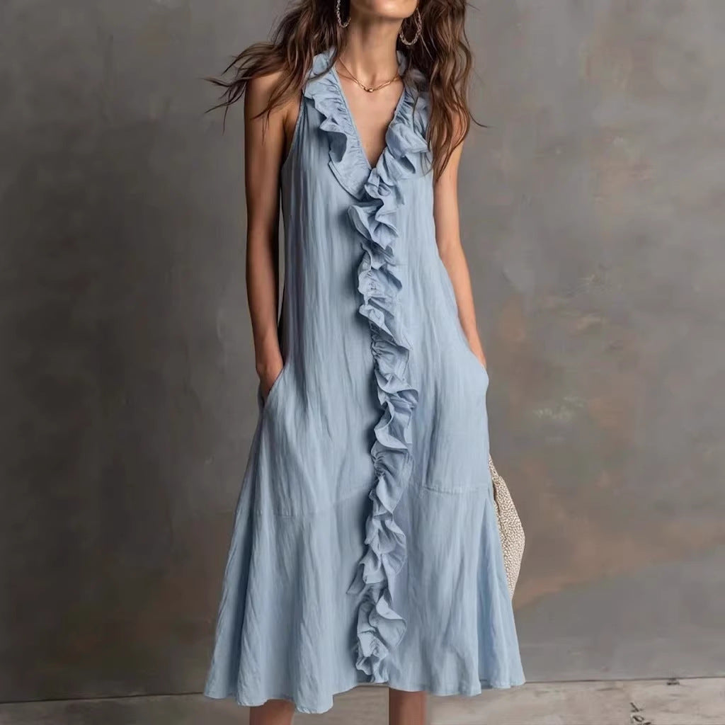 Woman wearing a light blue ruffled dress against a neutral background