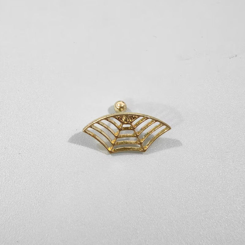 A small gold-toned fan-shaped jewelry piece with a web-like openwork design and a tiny central star detail, photographed on a light gray background.