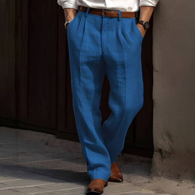 Person wearing blue pants and a white shirt leaning against a wall.