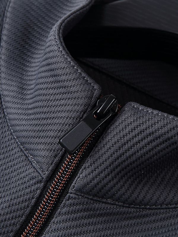 Close-up of a black textured fabric jacket with a visible zipper detail