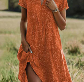 Person wearing an orange dress with a pattern in a natural setting