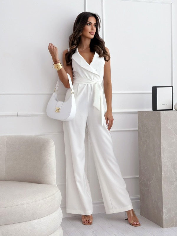 Woman in a white jumpsuit standing in a modern interior setting