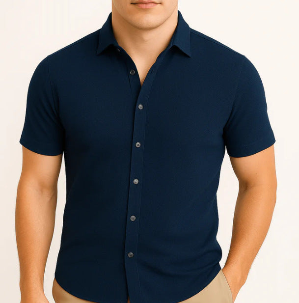 Navy blue short-sleeve button-up shirt worn by a person on a beige background