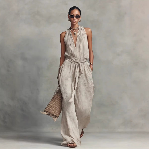 Woman wearing a flowing beige dress against a neutral background