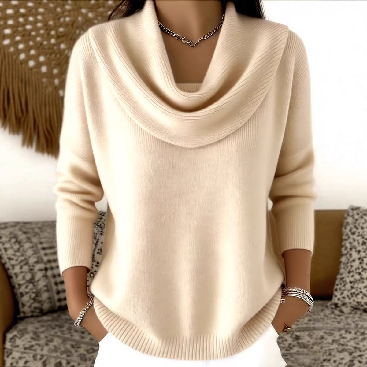 Beige sweater worn by a person with a blurred background