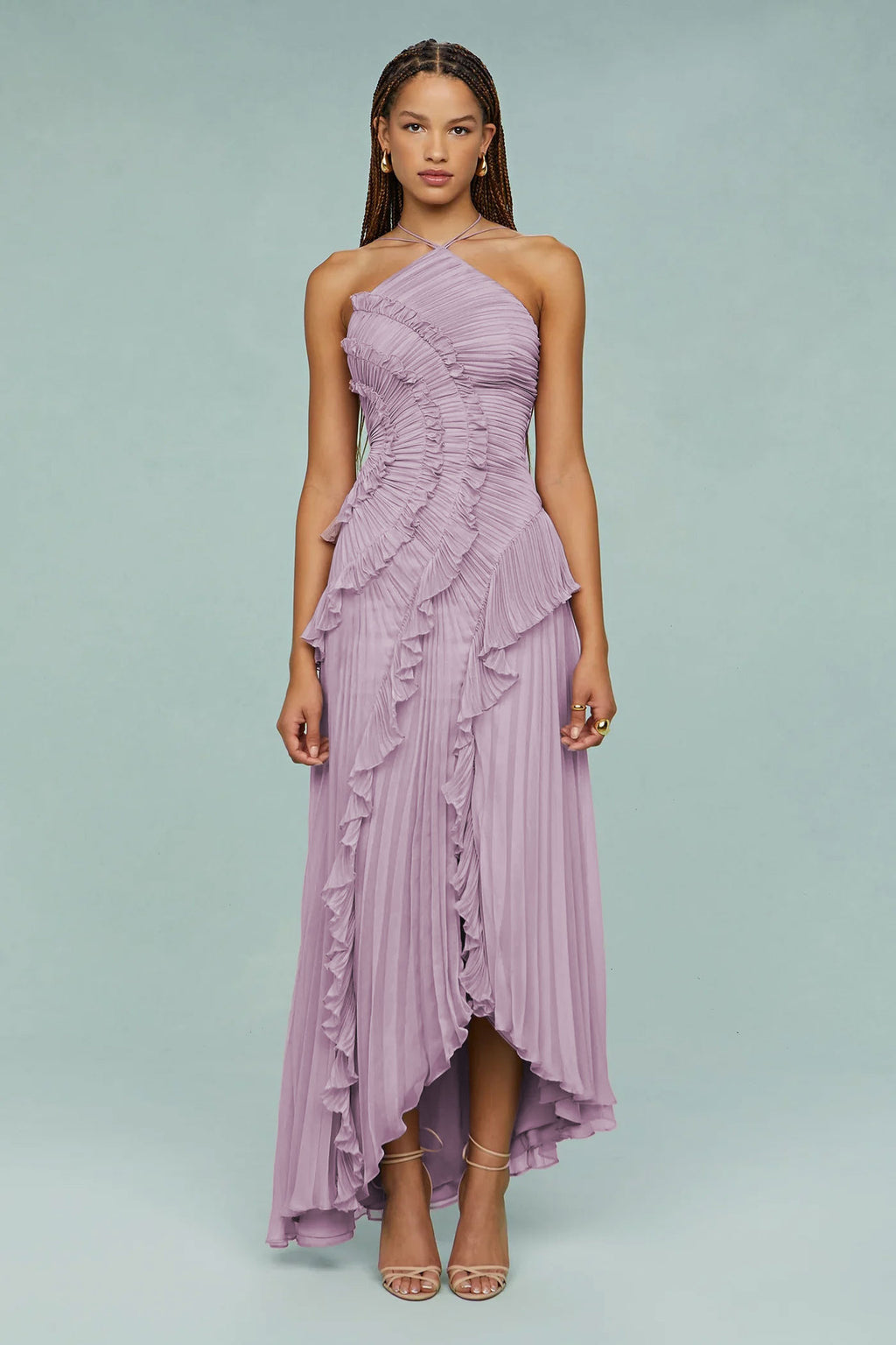 Woman wearing a one-shoulder ruffled purple dress on a light gray background