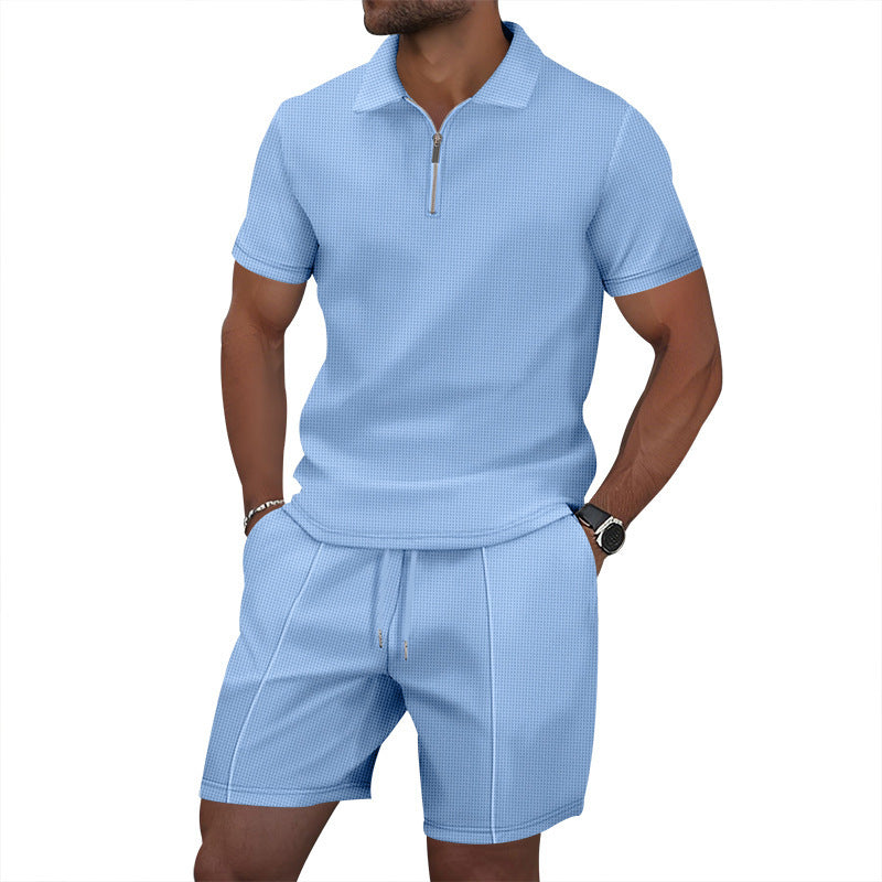 Man wearing a light blue polo shirt and shorts set on a white background