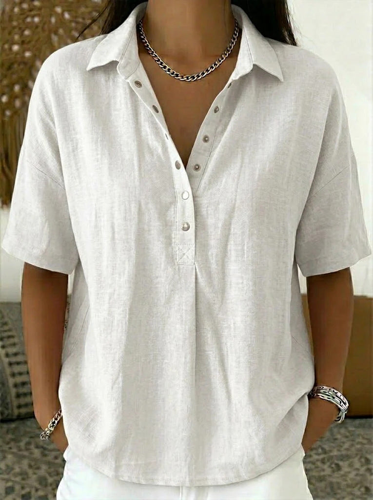 Person wearing a white button-up shirt with a neutral background