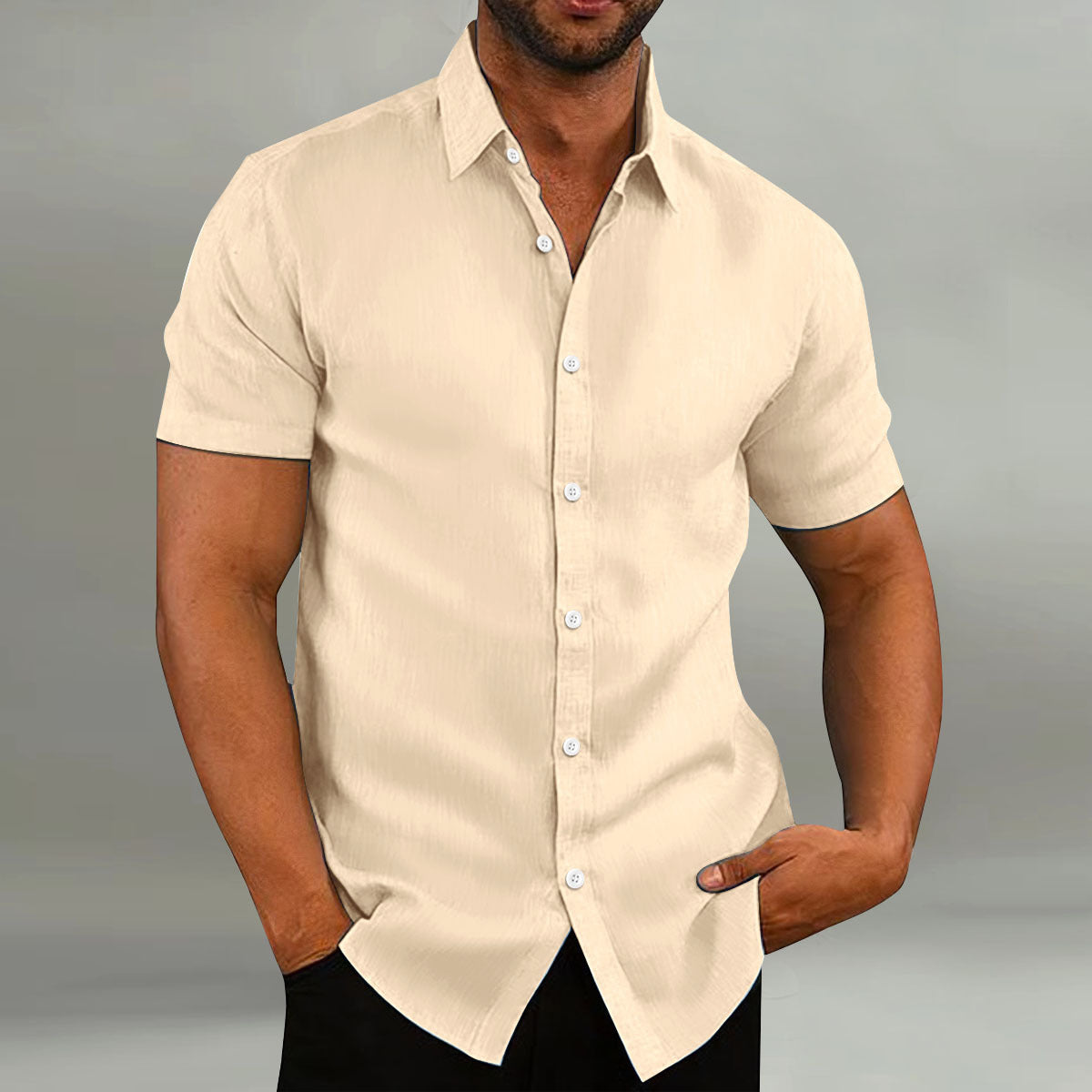 Man wearing a beige short-sleeve shirt against a gray background