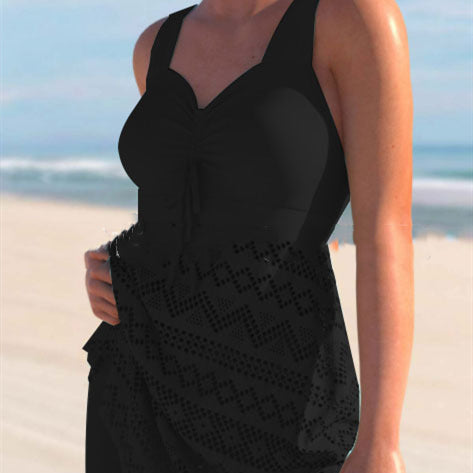 Person wearing a black sleeveless dress on a beach
