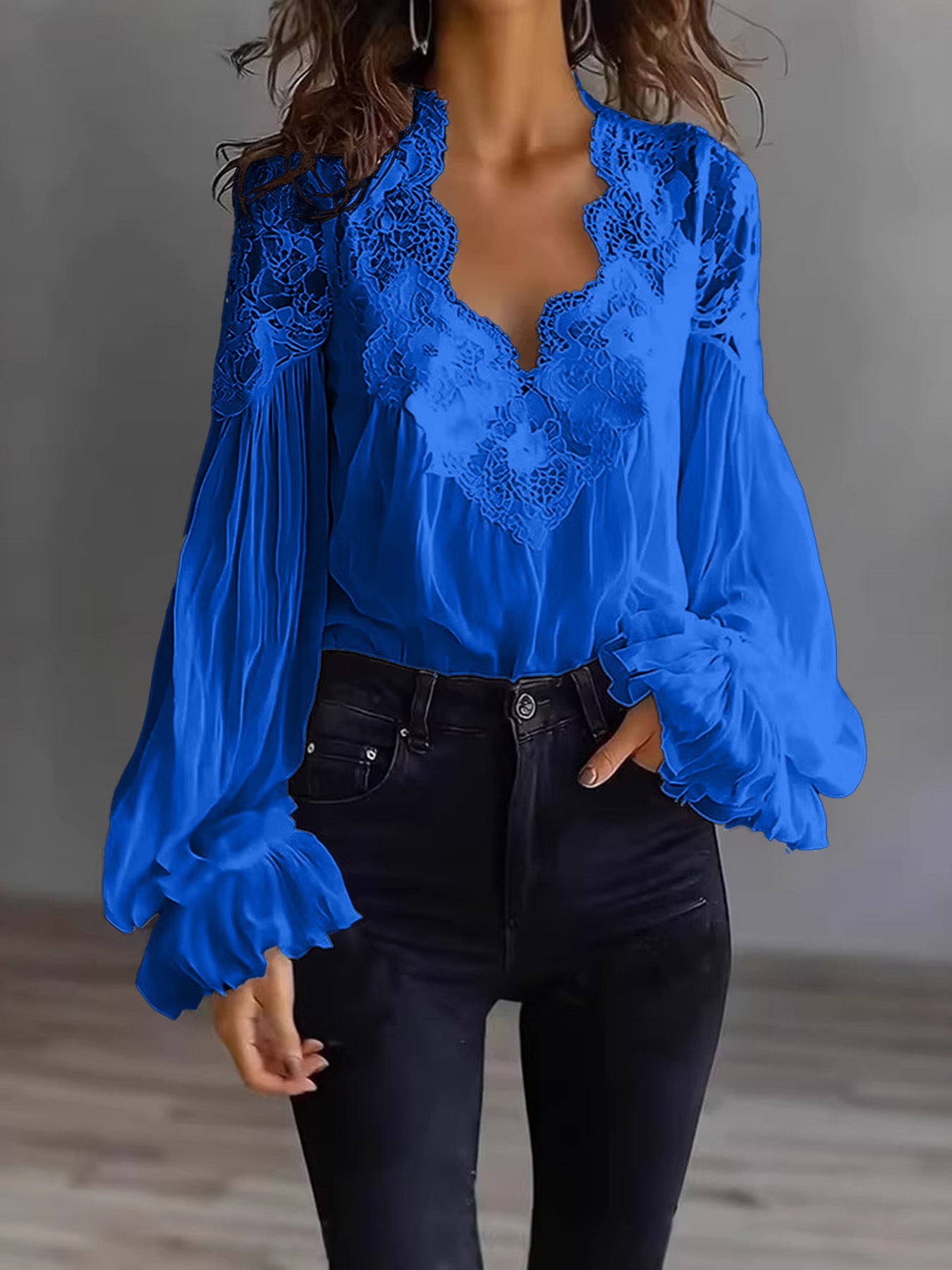 Blue lace blouse with long sleeves worn by a person against a neutral background