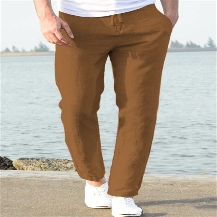 Person wearing brown pants standing by a body of water.