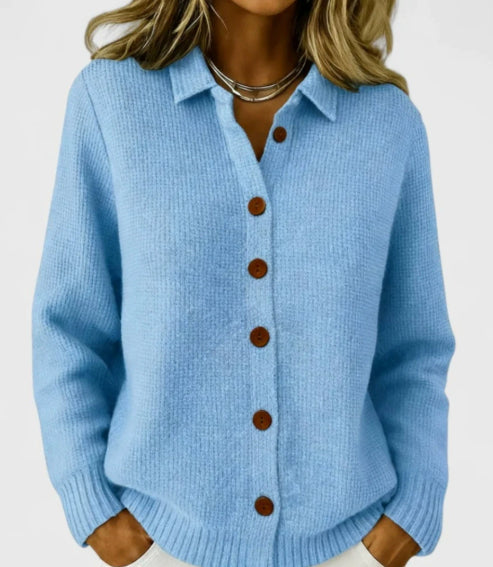 Light blue knitted cardigan with brown buttons on a plain background
