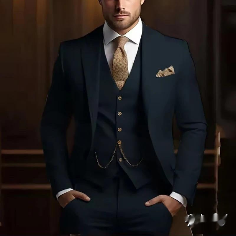 Man wearing a navy blue suit with a patterned tie and pocket square against a blurred background.