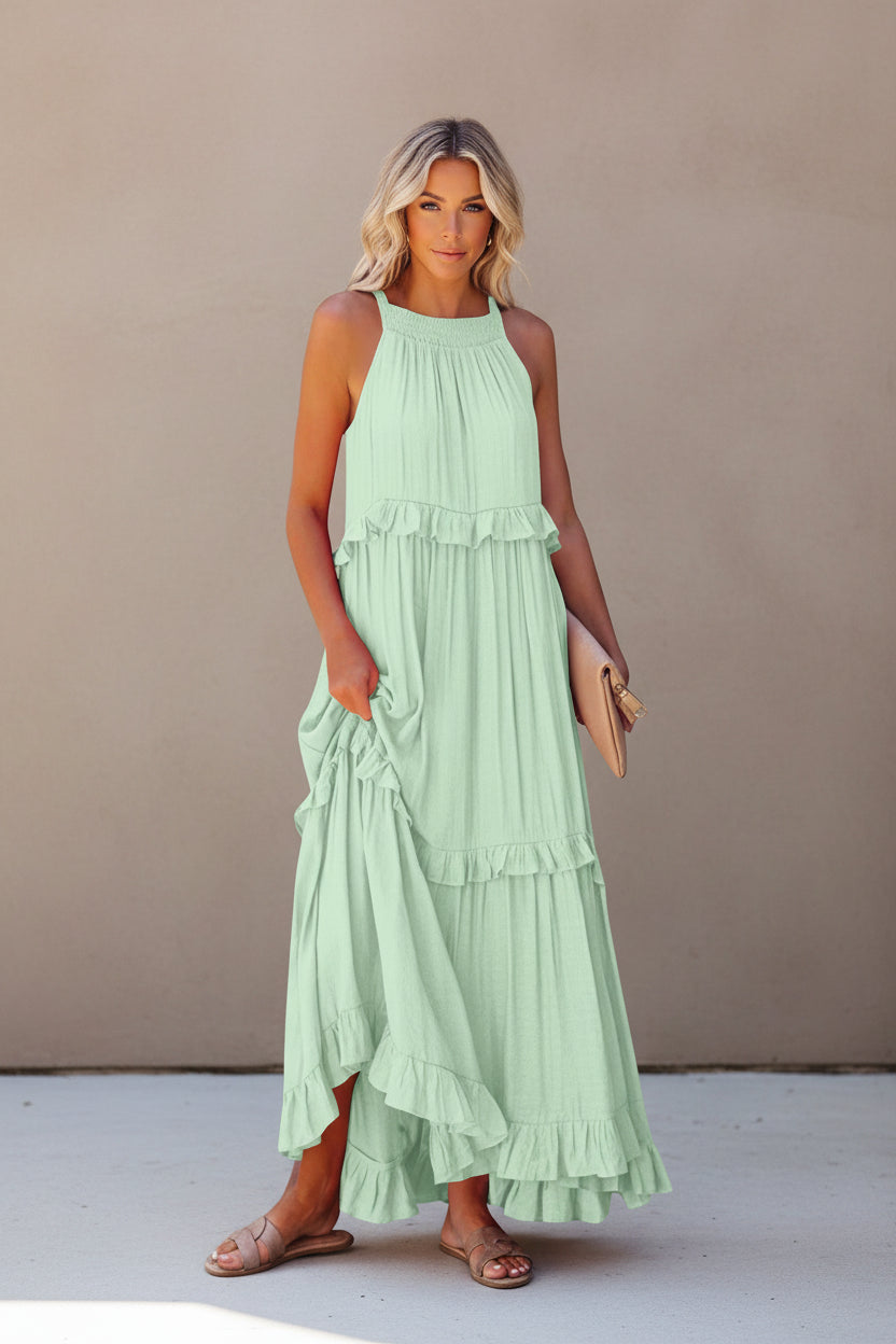 Woman wearing a light green tiered dress on a white background