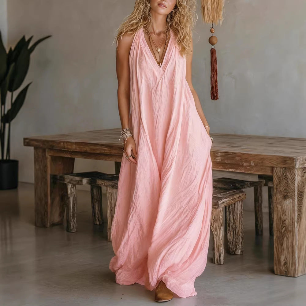 Woman in a pink dress standing in a room with wooden furniture and decor.
