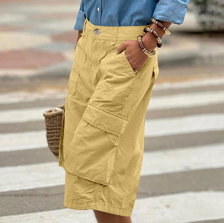 Person wearing yellow cargo shorts with a blurred background
