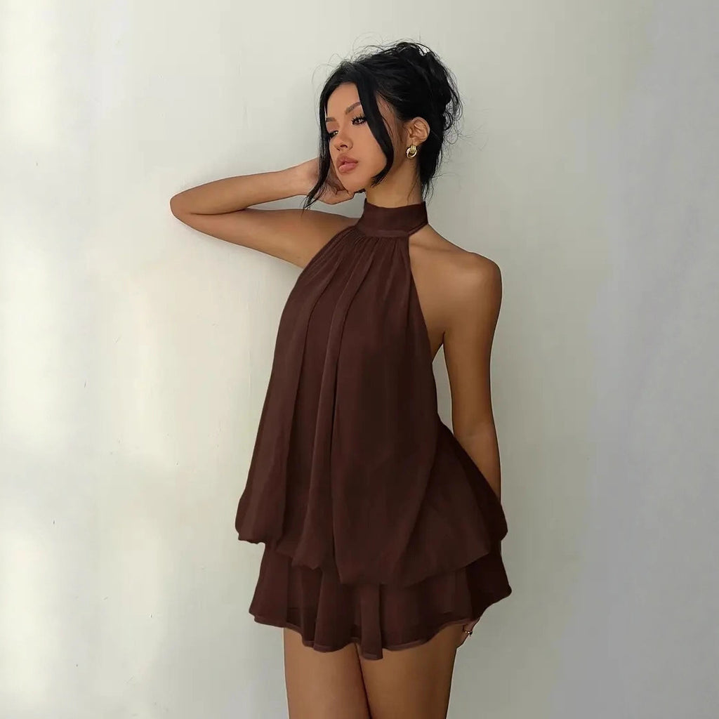 Woman wearing a brown halter neck dress against a plain background